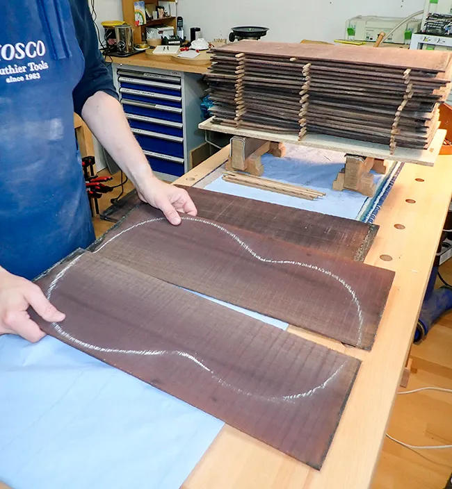 En gitarrmakare håller en ritning